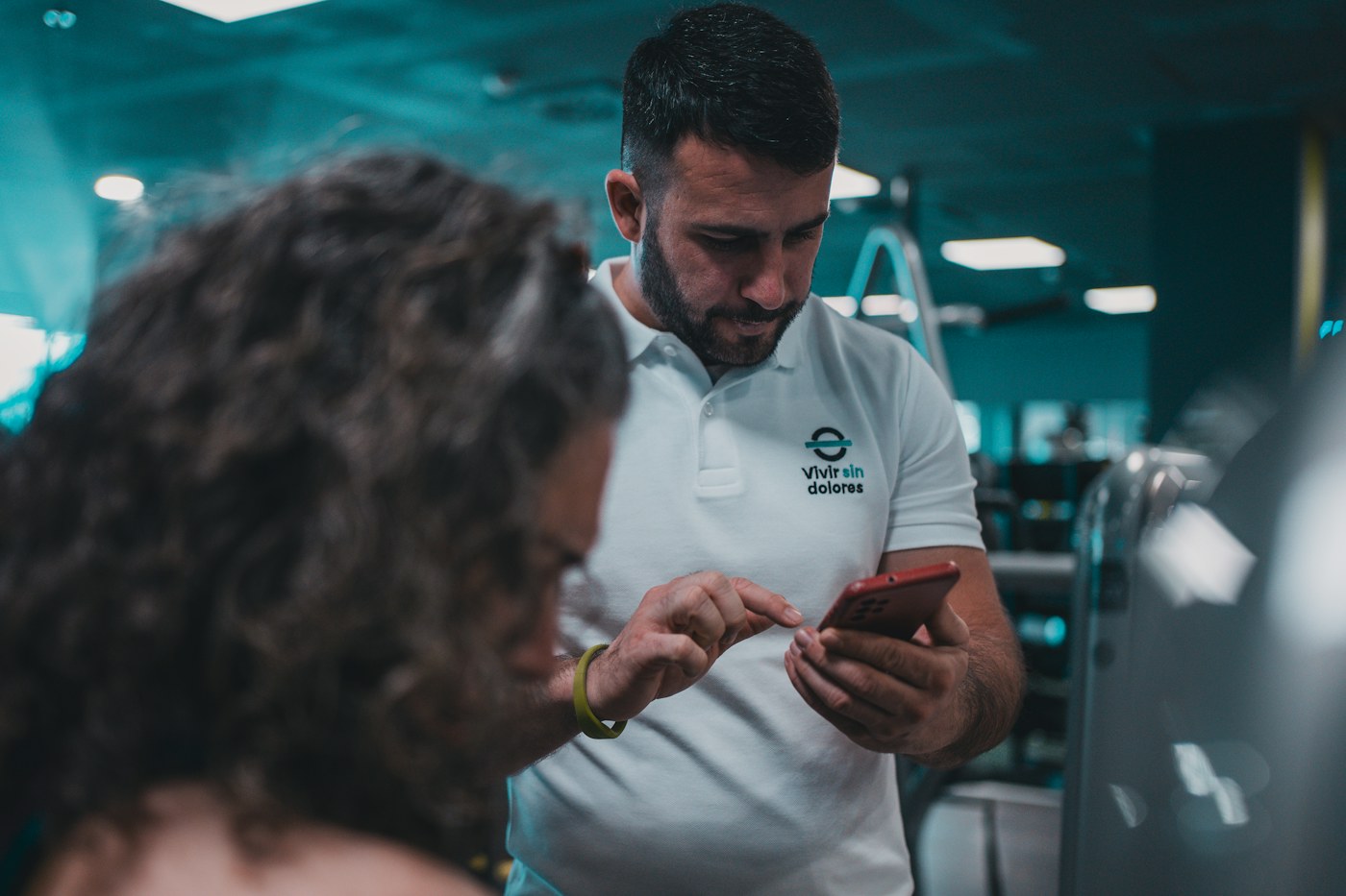 コーチと選手がスマートフォンの結果を見ている / Coach and athlete looking at results on a phone