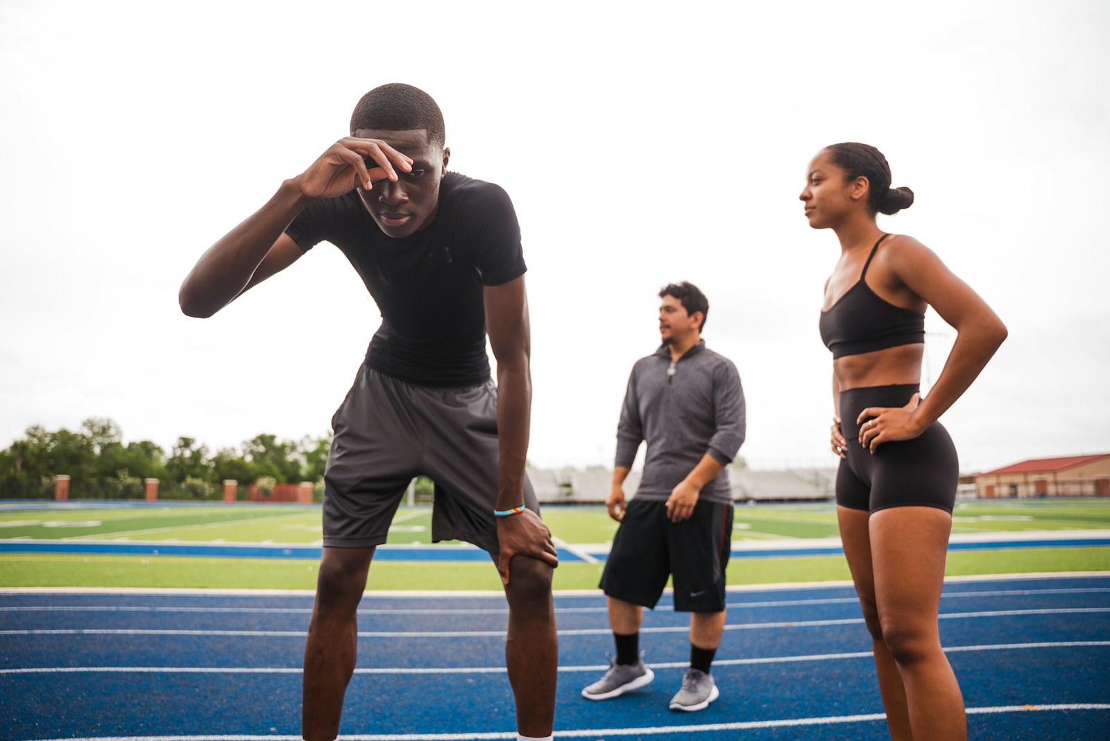 トラックでコーチと話す選手 / Athletes talking with a coach on the track